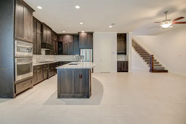 a large kitchen with stainless steel appliances granite countertop a sink and a stove