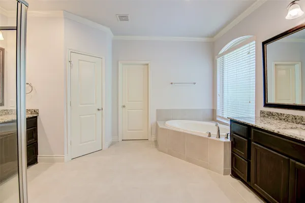 a bathroom with a tub sink and mirror