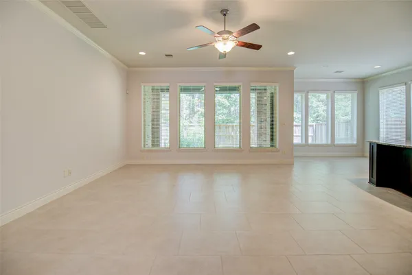 a view of an empty room with a window and a kitchen