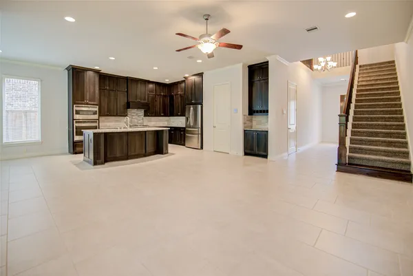 a large white kitchen with a large window a sink and stainless steel appliances