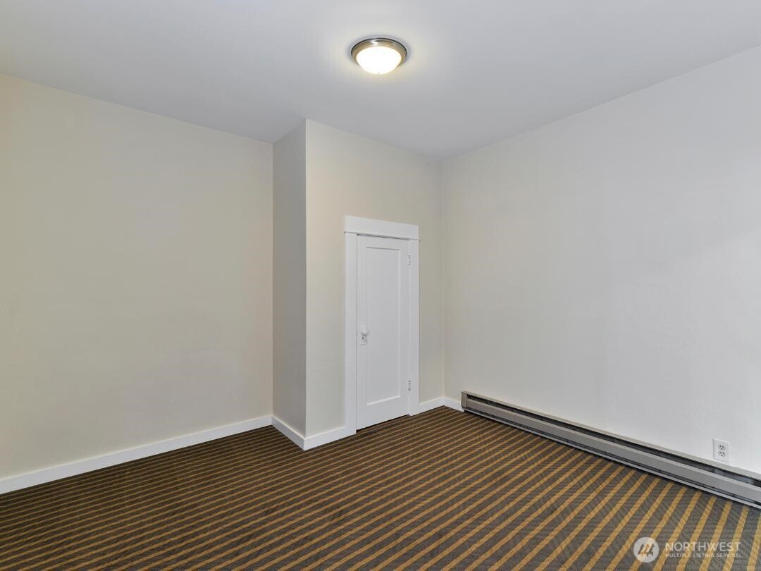 7519 Greenwood Avenue North, Unit 1 Seattle, WA 98103 - Photo 12 of 13 a view of an empty room with wooden floor and a window