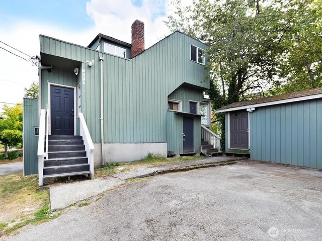 a view of a house with backyard and trees