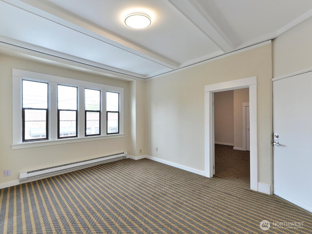 7519 Greenwood Avenue North, Unit 1 Seattle, WA 98103 - Photo 7 of 13 a view of an empty room with wooden floor and a window