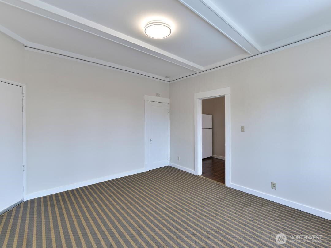 7519 Greenwood Avenue North, Unit 1 Seattle, WA 98103 - Photo 9 of 13 a view of an empty room with wooden floor