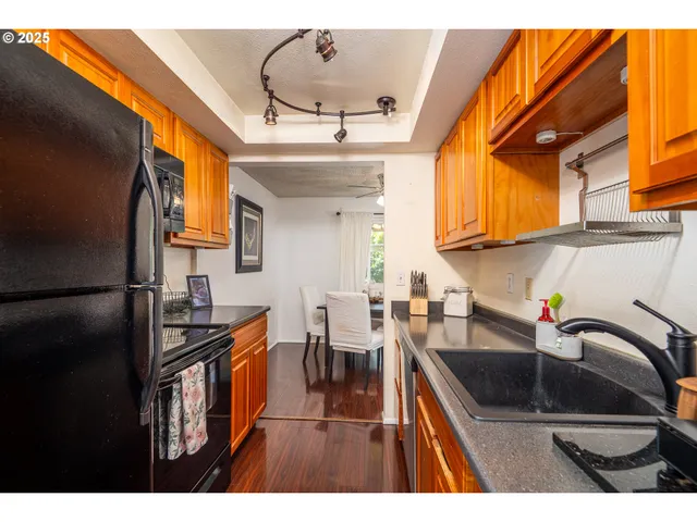 a kitchen with granite countertop a sink stainless steel appliances and cabinets