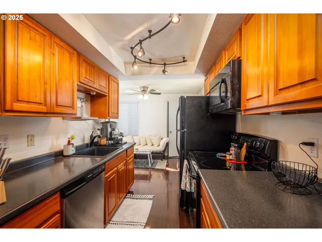 a kitchen with stainless steel appliances granite countertop a sink dishwasher stove and cabinets