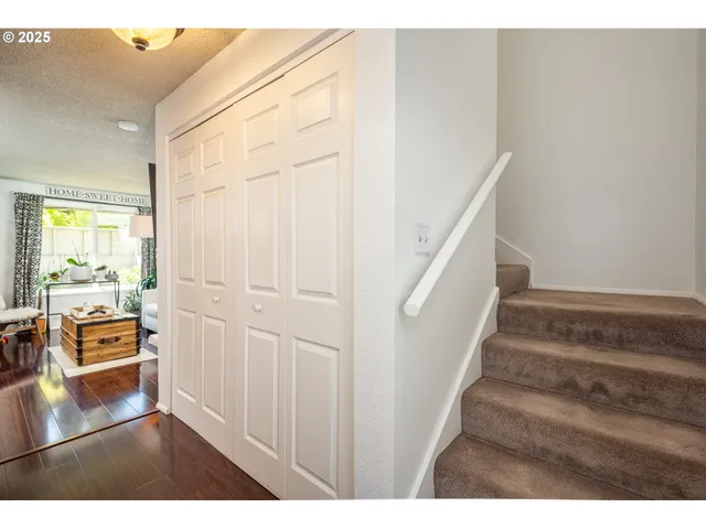 a view of a hallway with wooden floor and furniture
