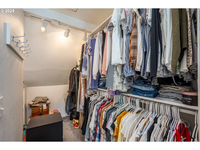 a view of walk in closet with clothes and shoes