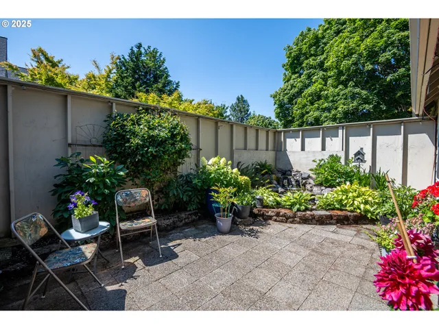 a backyard with potted plants and a bench