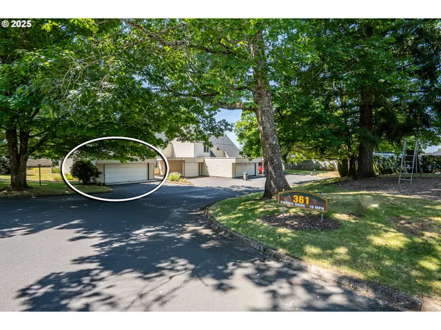 a backyard of a house with fire pit childrens swing and trees