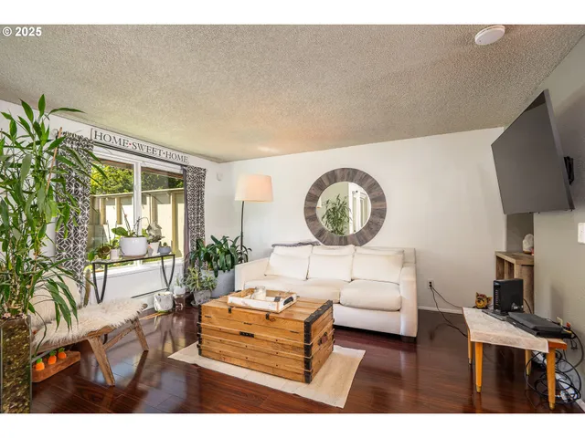 a living room with furniture a flat screen tv and a large window