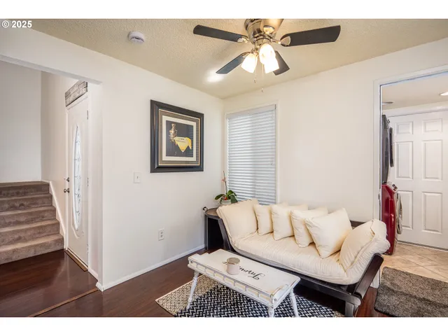 a living room with furniture and a ceiling fan