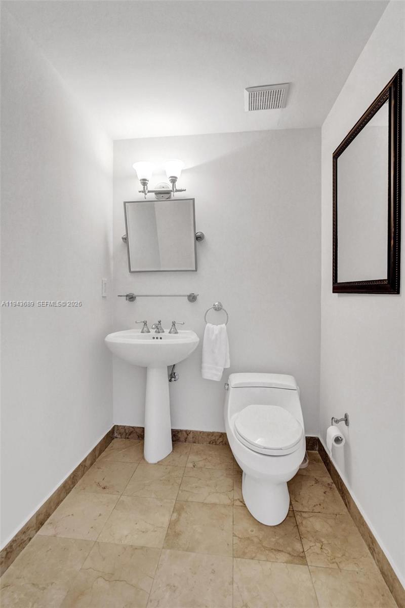 9595 Collins Avenue, Unit N8H Surfside, FL 33154 - Photo 12 of 35 a bathroom with a toilet sink and mirror