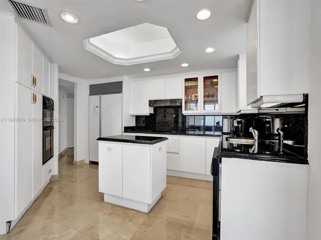 a kitchen with stainless steel appliances granite countertop a refrigerator and a stove top oven