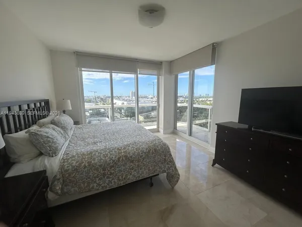 a bedroom with a bed and large window