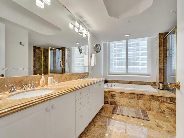 a spacious bathroom with a granite countertop double vanity and a large mirror