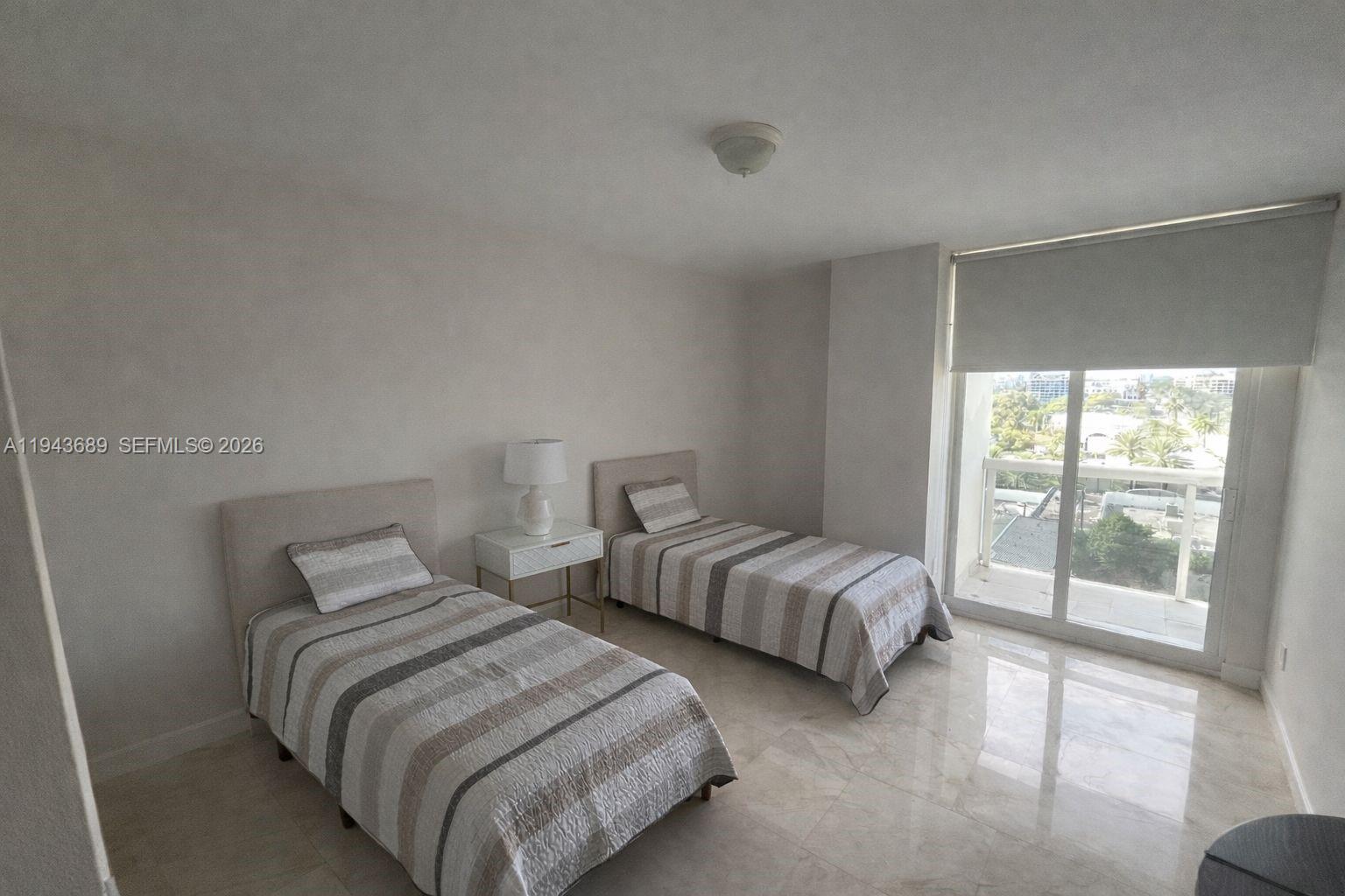 9595 Collins Avenue, Unit N8H Surfside, FL 33154 - Photo 10 of 35 a bedroom with two beds and a large window