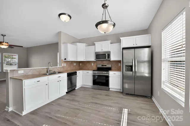 a kitchen with white cabinets and stainless steel appliances