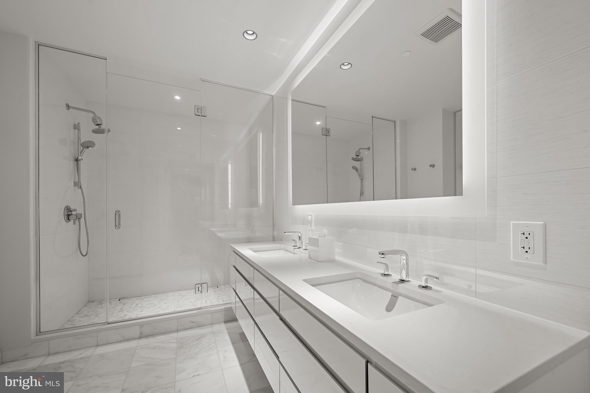 2501 M Street Northwest, Unit 311 Washington, DC 20037 - Photo 12 of 27 a bathroom with a shower sink vanity and mirror