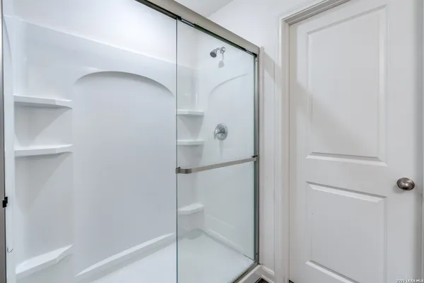 a bathroom with a glass shower door and a bathtub