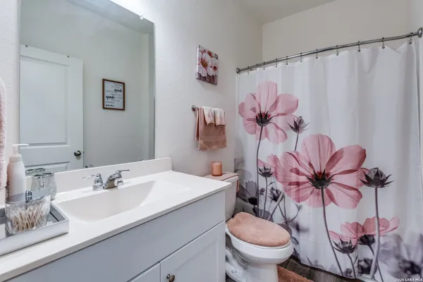 a bathroom with a sink a toilet and a mirror