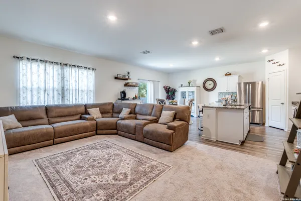 a living room with furniture and view of kitchen