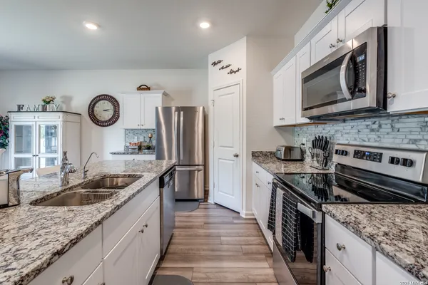 a kitchen with stainless steel appliances granite countertop a sink stove and microwave