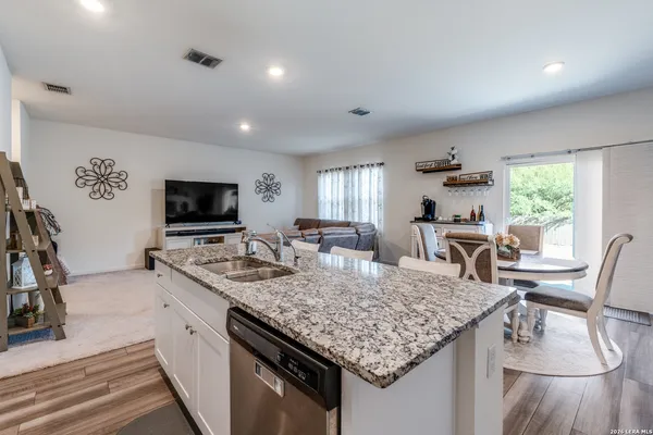 a kitchen with granite countertop kitchen island stainless steel appliances a sink and a center island