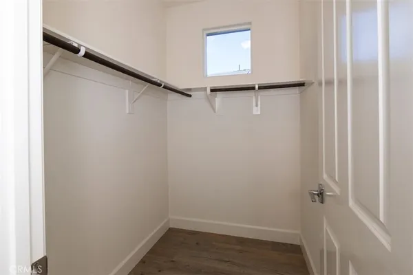 an empty room with wooden floor ceiling fan and windows