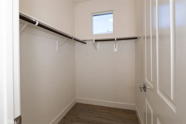 an empty room with wooden floor ceiling fan and windows