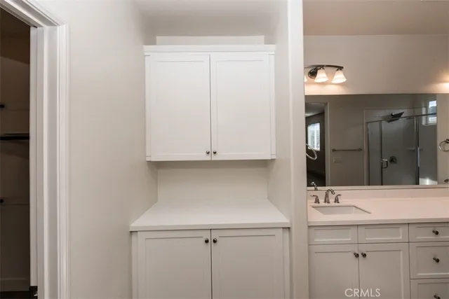 a bathroom with a double vanity sink and mirror with shower
