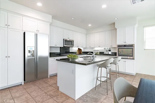 a kitchen with stainless steel appliances granite countertop a refrigerator stove microwave and sink