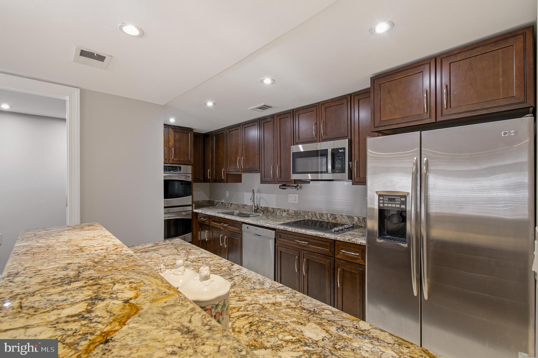2117 S Street Northwest Washington, DC 20008 - Photo 45 of 63 a kitchen with granite countertop stainless steel appliances and wooden cabinets