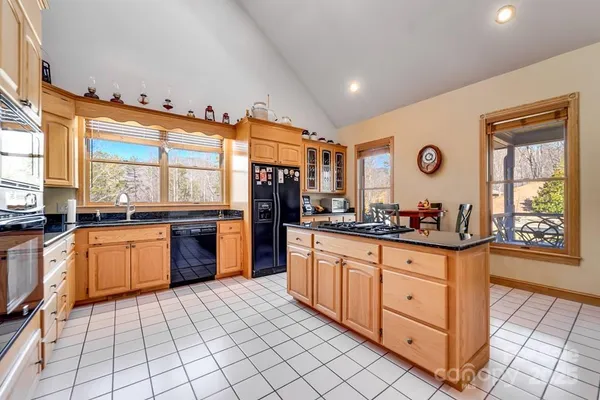 a kitchen with stainless steel appliances granite countertop a stove a sink and a refrigerator