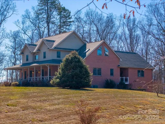 a view of a house with a yard and large tree