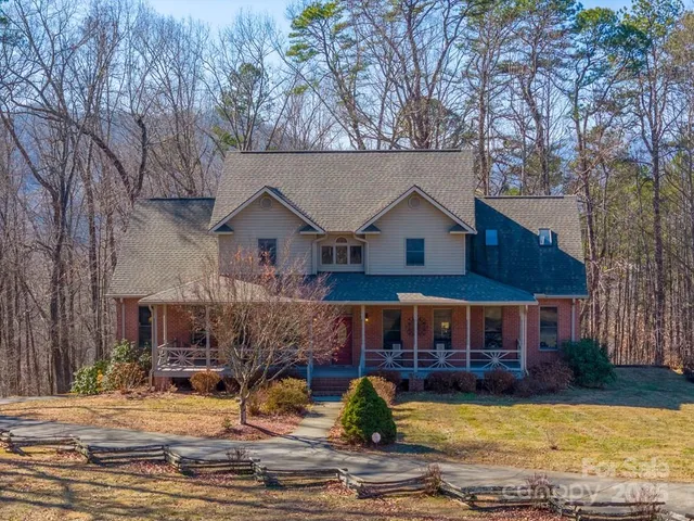 a view of a house with swimming pool next to a yard