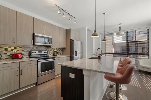 a kitchen with stainless steel appliances granite countertop a sink a stove and a refrigerator