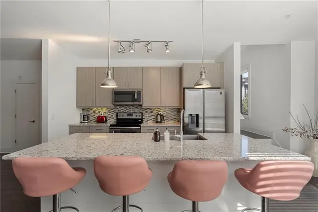 a kitchen with stainless steel appliances granite countertop a sink refrigerator and microwave