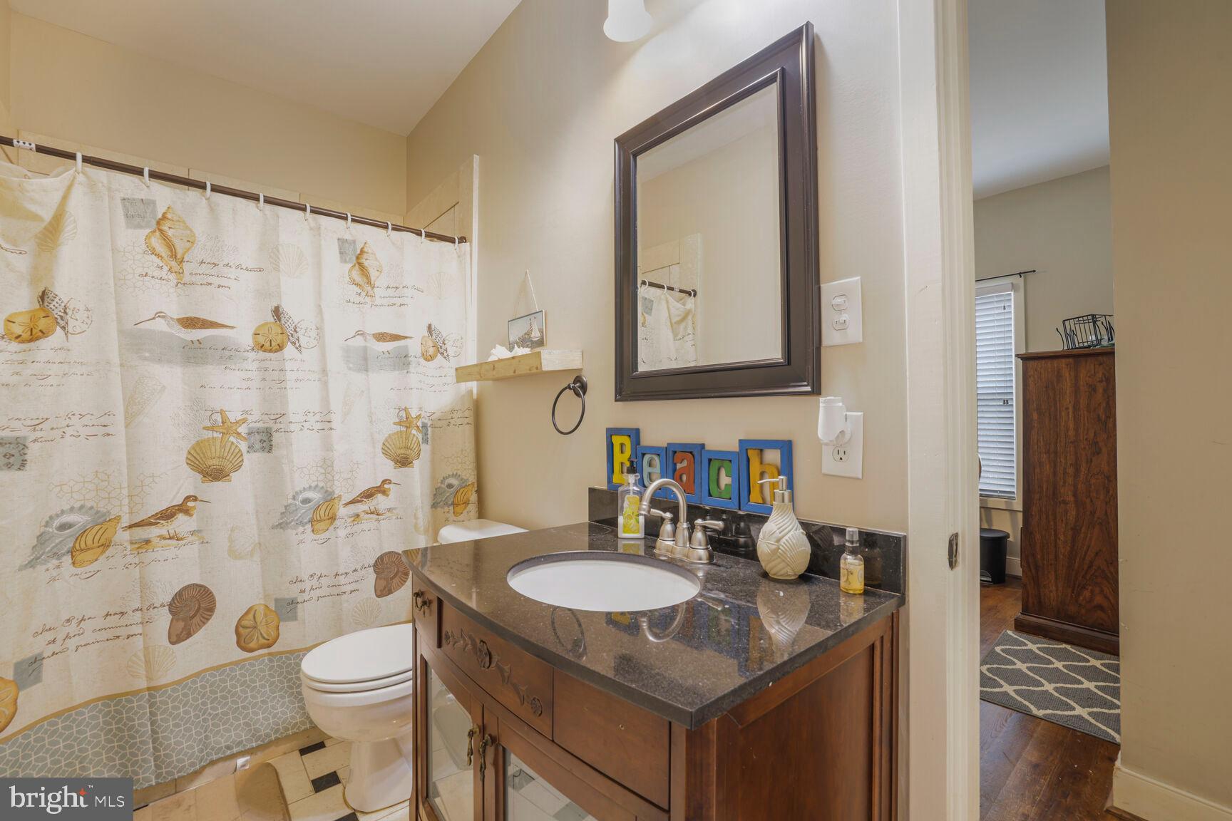 6231 Woodville Road Mount Airy, MD 21771 - Photo 22 of 29 a bathroom with a granite countertop sink toilet and shower