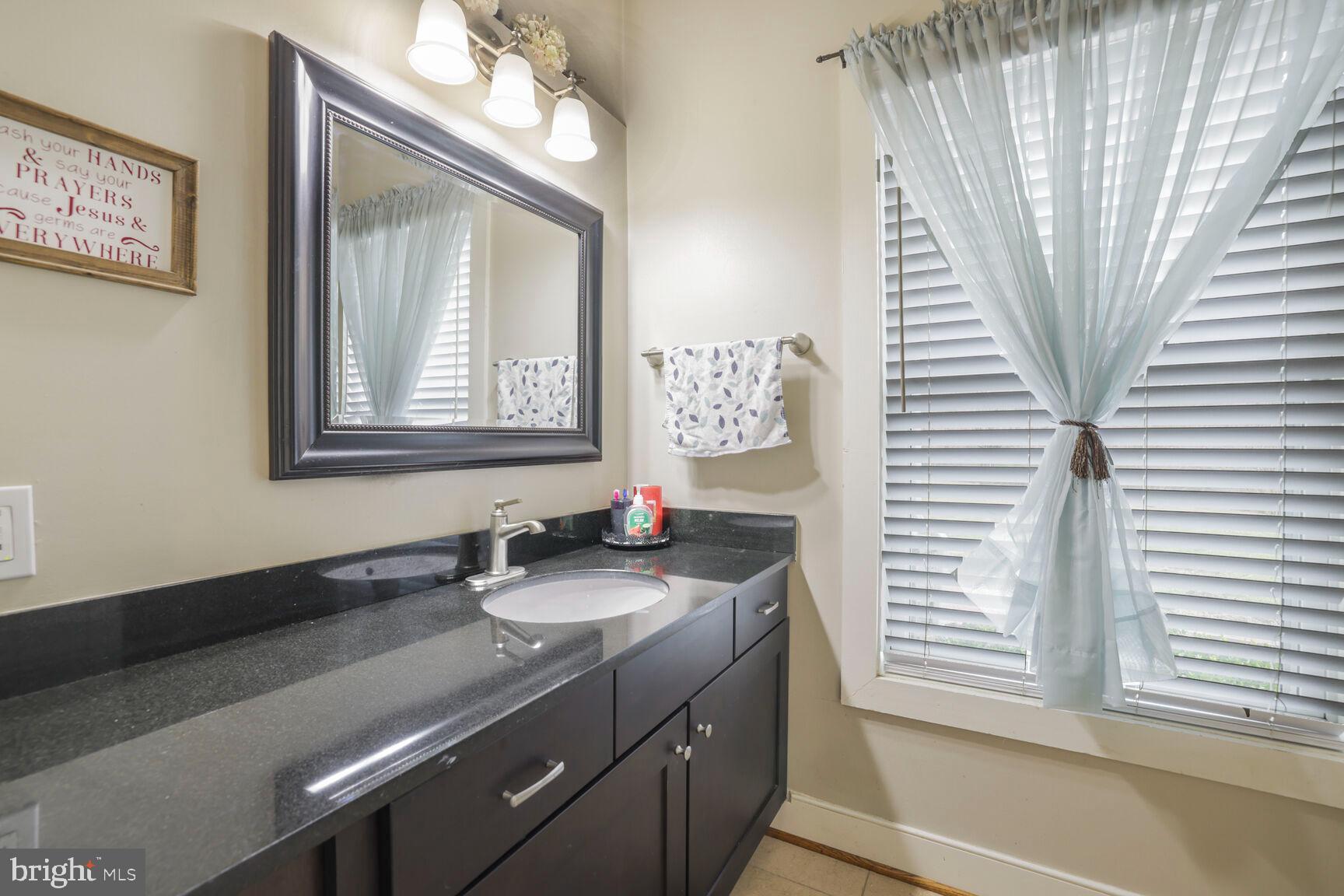 6231 Woodville Road Mount Airy, MD 21771 - Photo 24 of 29 a bathroom with a double vanity sink and a mirror