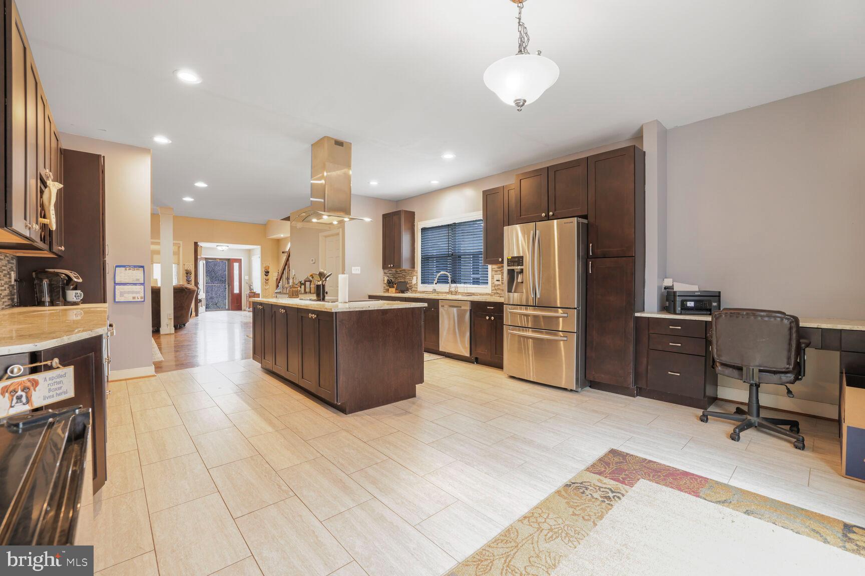 6231 Woodville Road Mount Airy, MD 21771 - Photo 8 of 29 a kitchen with stainless steel appliances kitchen island granite countertop a table chairs refrigerator and a sink