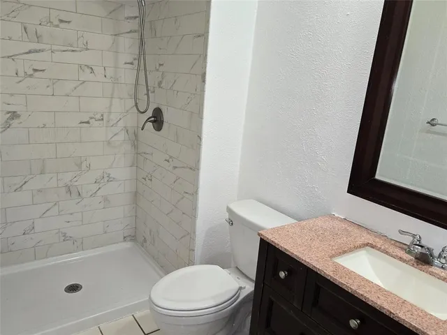 a bathroom with a granite countertop sink toilet and shower