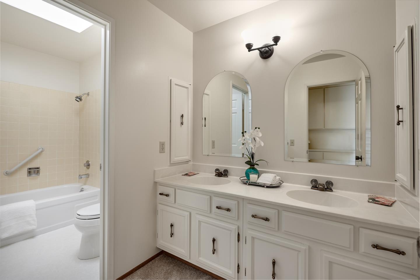 2516 Sherborne Drive Belmont, CA 94002 - Photo 18 of 25 a bathroom with a double vanity sink a toilet a mirror and shower