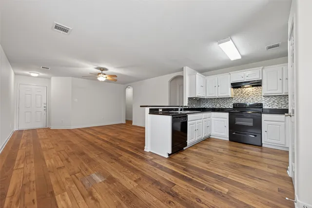 a kitchen with granite countertop a refrigerator and steel stove top oven