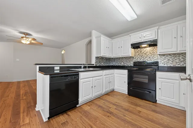 a kitchen with granite countertop white cabinets and appliances