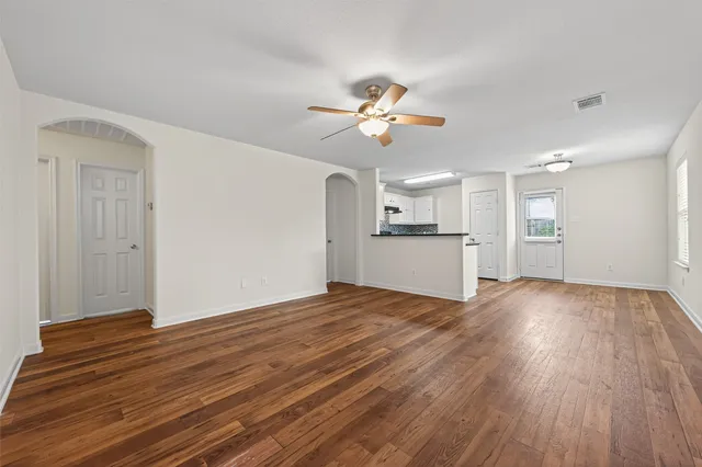 a view of a kitchen with wooden floor and a ceiling fan
