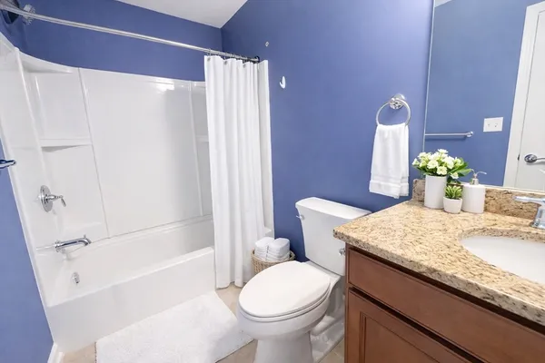 a bathroom with a granite countertop sink toilet and shower