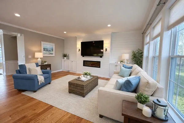 a living room with furniture flat screen tv and wooden floor