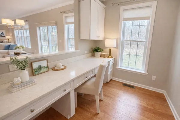 a kitchen with a table chairs white cabinets and wooden floor