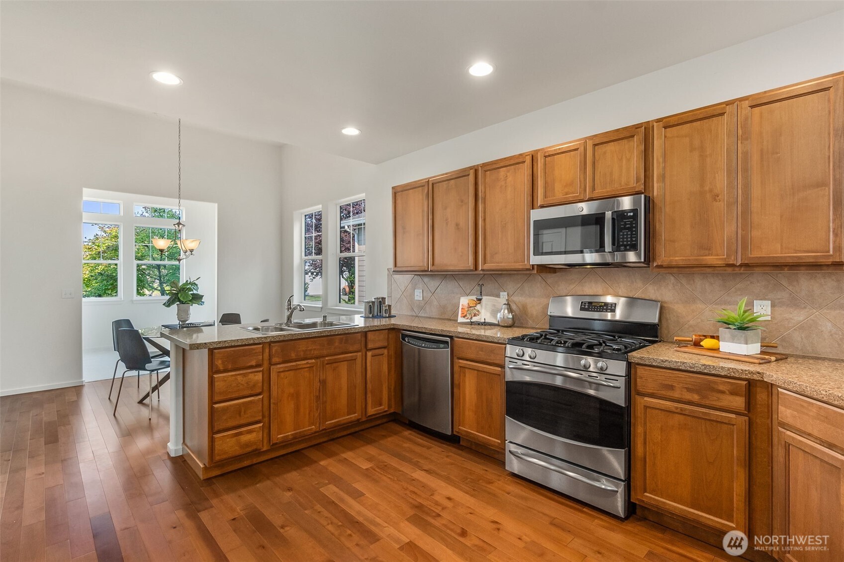 8231 Orcas Loop Northeast Lacey, WA 98516 - Photo 9 of 23 a kitchen with stainless steel appliances granite countertop wooden cabinets stove top oven and sink